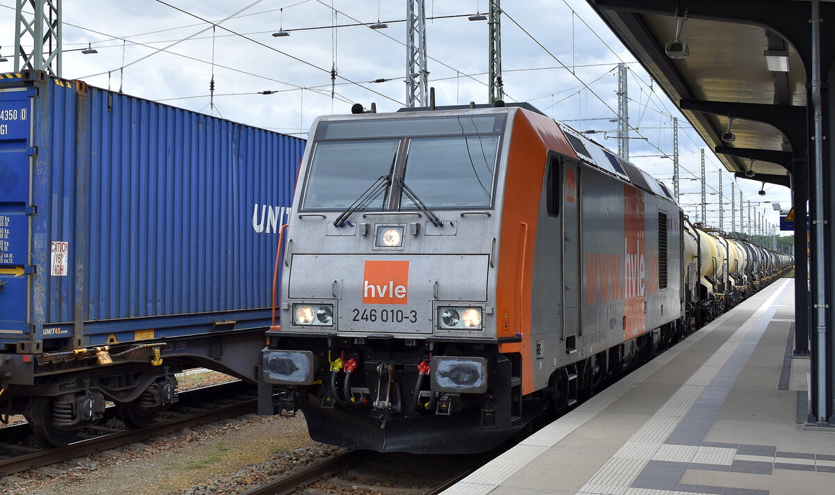 Havelländische Eisenbahn AG, Berlin-Spandau (HVLE) mit ihrer  246 010-3  (NVR:  92 80 1246 010-3 D-HVLE ) und einem Kesselwagenzug (Schwefelsäure) am 03.07.24 Durchfahrt Bahnhof Ruhland.