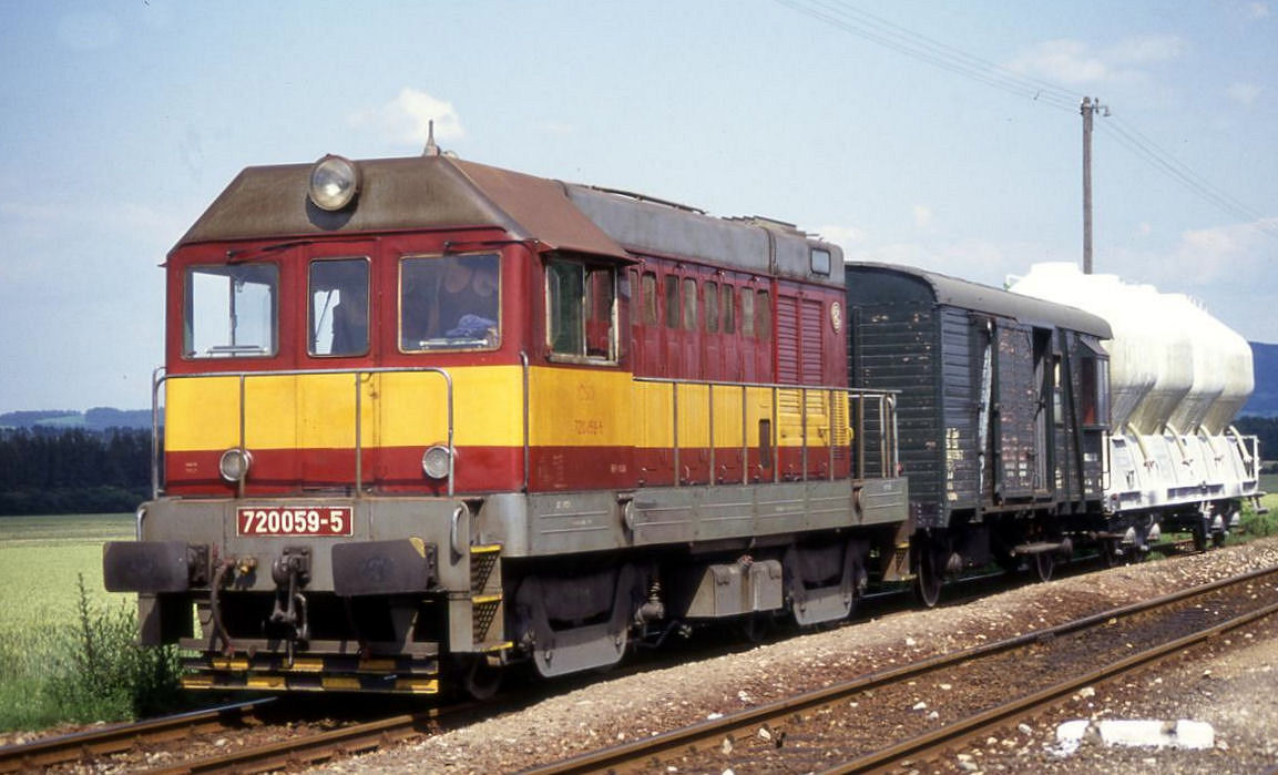 Hector 720059 wartet im Landbahnhof Skovice am 28.6.1992 um 16.00 Uhr mit einem kurzen Güterzug auf der Fahrt nach Caslav die Zugkreuzung mit dem entgegen kommenden Triebwagen aus Caslav ab.