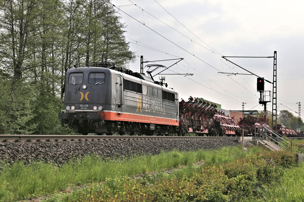 Hectorrail 162.010 ist hier mit einem Spezial Wagen Zug für Stahlplatten auf der Rollbahn am Ortsrand von Hasbergen am 4.5.2022 um 09.13 Uhr in Richtung Ruhrgebiet unterwegs.