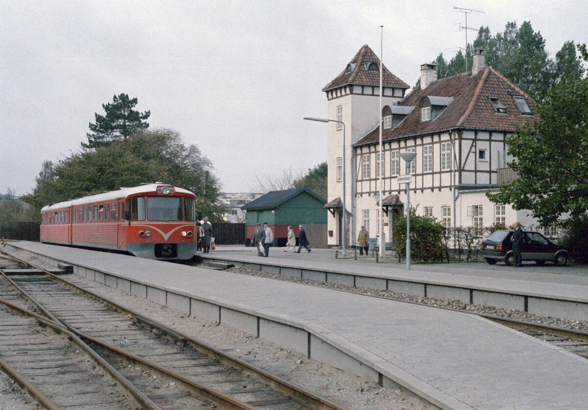 Helsingør-Hornbæk-Gilleleje-Banen (HHGB, Hornbækbanen): Im Bahnhof (Helsingør-) Grønnehave hält eines Tages im Oktober 1985 ein Triebzug, der aus einem Triebwagen des Typs Ym (hinten) und einem Steuerwagen des Typs Ys (vorne) besteht. Der Zug fährt in Richtung (DSB-) Bahnhof Helsingør. - Im Bahnhof Grønnehave befand sich die Verwaltung der HHGB. - Scan eines Farbnegativs. Film: Kodak CL 200 5093. Kamera: Minolta XG-1.