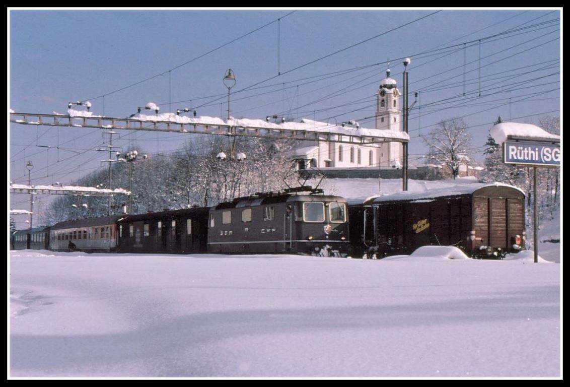 Heute ein paar Dia-Scan aus dem Jahre 1975 aus meiner Zeit als Betriebsdisponent im damals noch viergleisigen Bahnhof Rüthi SG. Zugskreuzung in Gleis 3 und 4. Gleis 1 und 2 sind eingeschneit. An zweiter Stelle hinter dem Postwagen befindet sich ein Kurswagen nach Chur, entweder aus München oder Stuttgart. Beides gab es einmal.