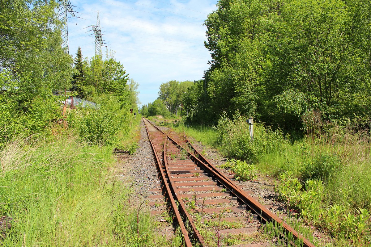 Heute präsentiere ich Teil 4 von der ehemaligen ZCM Industriebahn (Zwickau-Crossen-Mosel), die eine Gesamtlänge von 7,996 km hatte. Sie wurde im April 1892 als Normalspur gebaut und wurde mit einem Festakt am 08.07.1893 eröffnet. Sie wurde gebaut um die Papierfabrik C. F. Leonhardt in Crossen zu beliefern und bis zum Ersten Weltkrieg siedelten sich bedeutende Unternehmen wie  August Horch, später Audi, und bei Crossen entstand eine Verladeanlage des Sandwerk Oberrothenbach.
Nach dem Zweiten Weltkrieg wurde die Papierfabrik und die Verladeanlage von der Sowjetischen Besatzungsmacht als Reparationsleistung abgebaut. 1948 wurde Sie wieder aufgebaut und in einen Volkseigenen Betrieb umgebaut. Viele Firmen entlang der Strecken hatten einen Bahnanschluss.

Eine Zäsur für die Strecke war 1989 die politische Wende im Osten Deutschlands. Innerhalb kürzester Zeit stellten fast alle Betriebe entlang der Trasse ihre Produktion ein und die Streckenauslastung verringerte sich drastisch.

Am 10.12.1998 wurde die Stilllegung und Abbau der Nebenbahn bis zum km 2,650 vom Eisenbahnbundesamt beschlossen. Ein Großteil der Strecke hat man in einen Rad- und Fußweg verwandelt.

Iher hat man den Blick vom Bü Schubertstraße, am Km 3,870, in Richtung Crossen. Die Anschlussgleise die rechts abgeht teilt sich in drei Gleise auf und führt weiter zu der Spedition Sachsentrans, die mit zur Schenllecke Logistics gehört.
