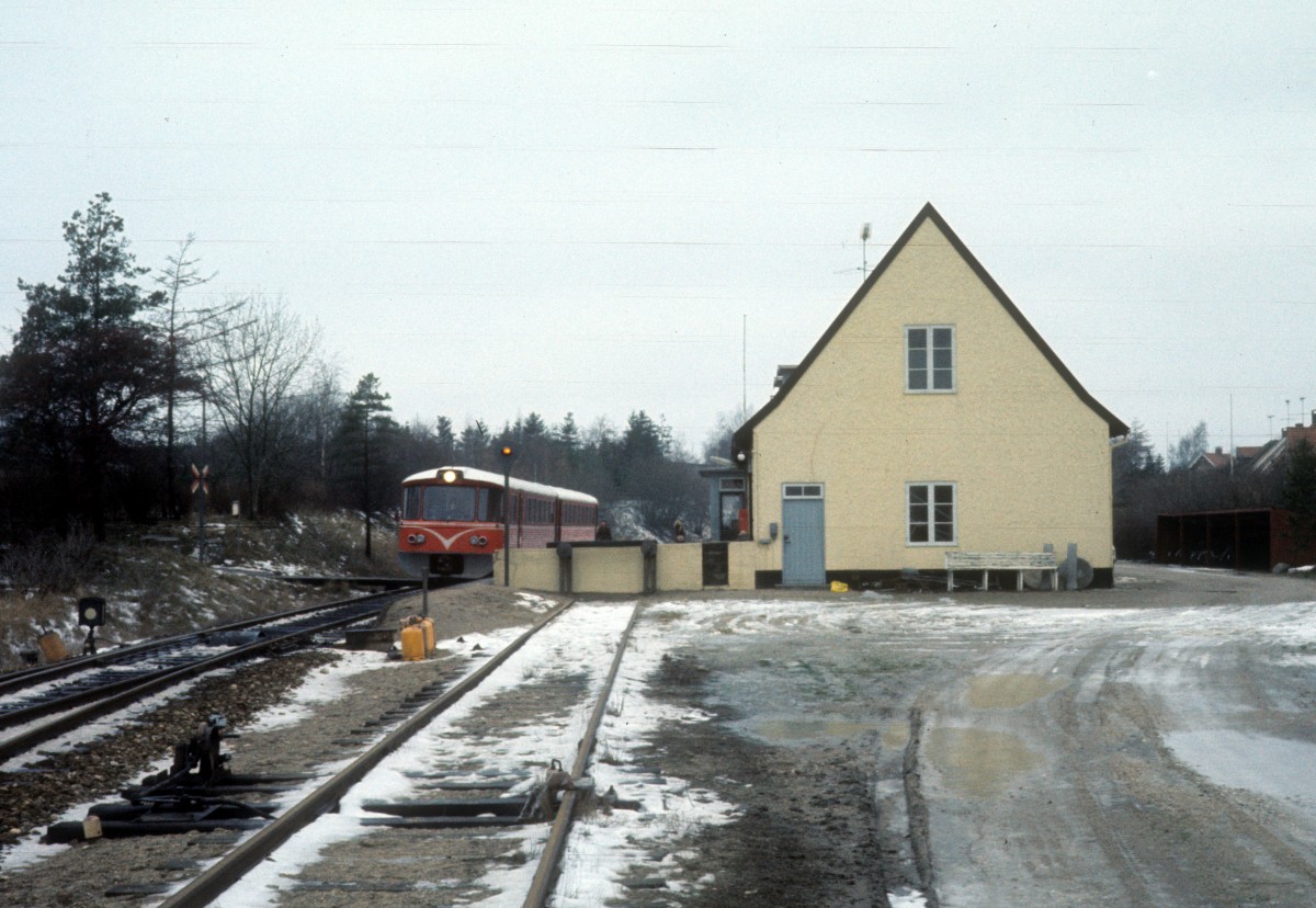 HFHJ (Hillerød-Frederiksværk-Hundested-Jernbane): Bahnhof Gørløse am 23. Dezember 1976. Am Bahnsteig hält ein Triebzug (Ym + Ys) in Richtung Hillerød.
