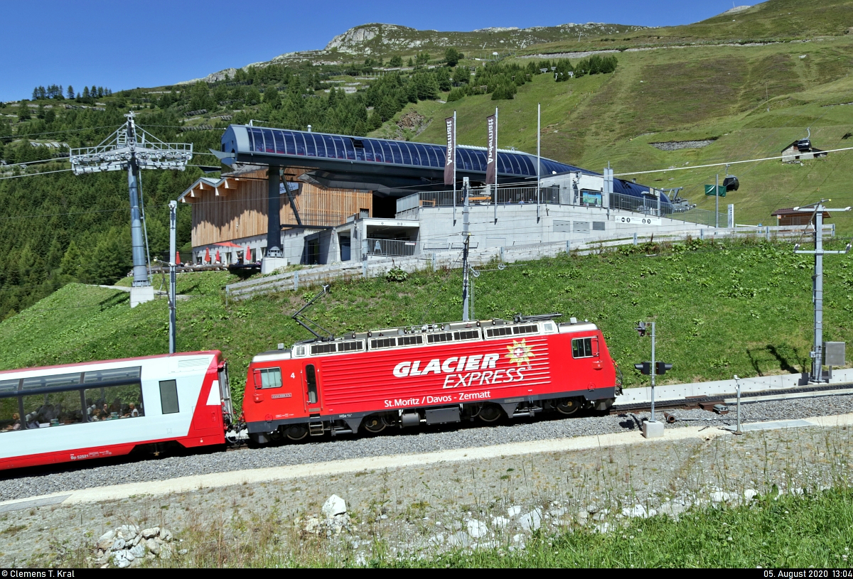 HGe 4/4 II 4  Täschhorn  fährt vorbei an der Mittelstation der Gondelbahn Andermatt–Gütsch ( Gütsch-Express ) am Nätschen (CH).

🧰 Matterhorn-Gotthard-Bahn (MGB)/Rhätische Bahn (RhB)
🚝 D 904 (Glacier Express) Zermatt (CH)–St. Moritz (CH)
🚩 Bahnstrecke Brig–Disentis/Mustér (Furka-Oberalp-Bahn (FO) | 144)
🕓 5.8.2020 | 13:04 Uhr