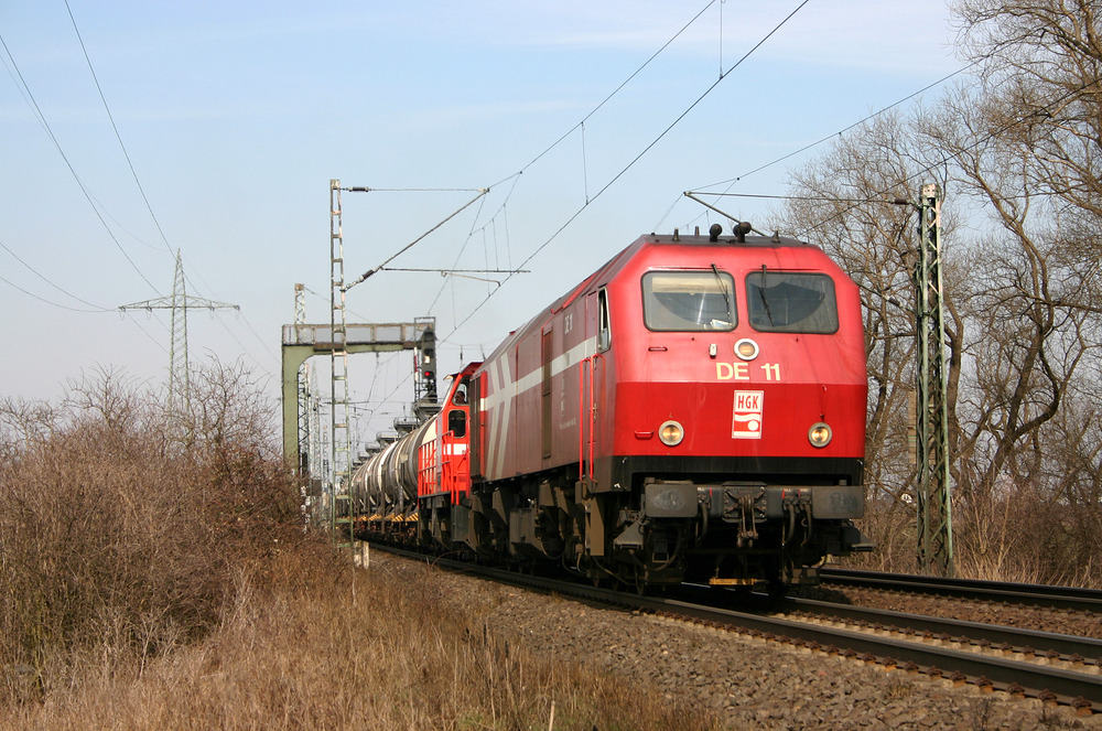 HGK DE 11 und eine DE 1002 der HGK mit dem Wasserglaszug auf dem Weg von Düsseldorf-Reisholz nach Köln-Godorf Hafen.
Aufgenommen in Hürth am 15.03.2006.