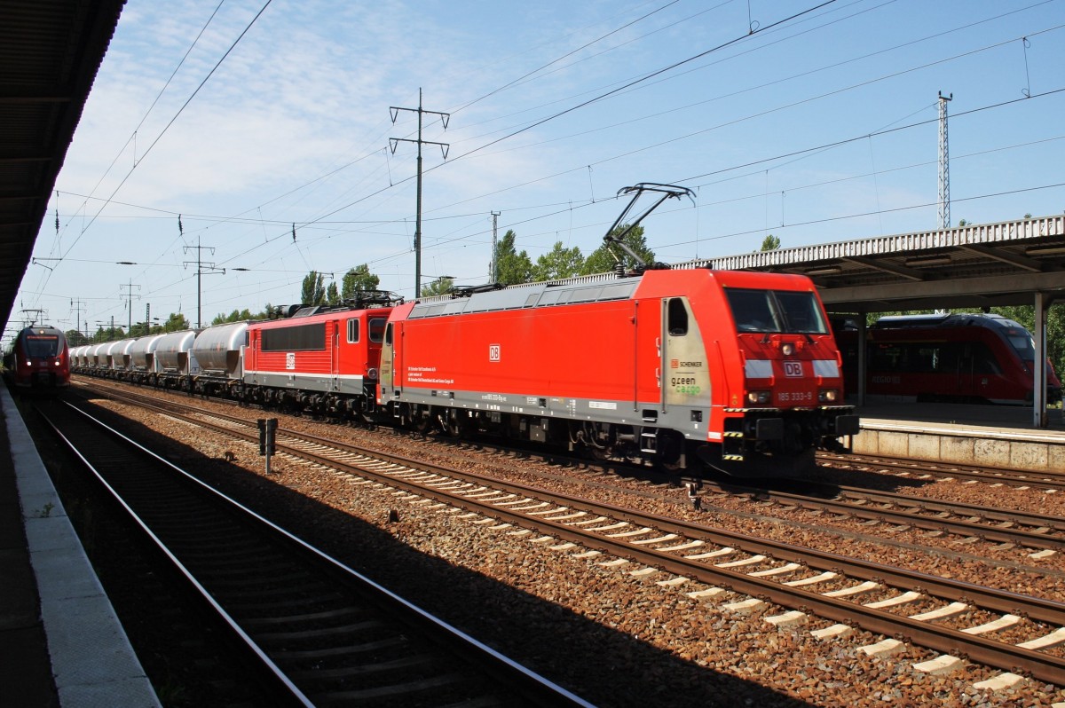 Hier 185 333-9 und 155 119-1 (abgebügelt) mit einem Güterzug, bei der Durchfahrt am 1.8.2015 durch Berlin Schönefeld Flughafen, in Richtung Berlin Grünauer Kreuz.