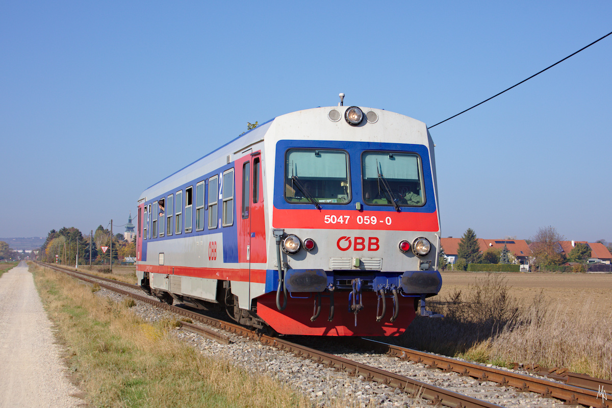 Hier eine Bildvariante der Stammersdorfer Lokalbahn mit der Kirche von Pillichsdorf im Hintergrund. Zu sehen ist hier der Triebwagen 5047 059 auf der Fahrt von Obersdorf nach Groß Schweinbarth am 27. Oktober 2019.