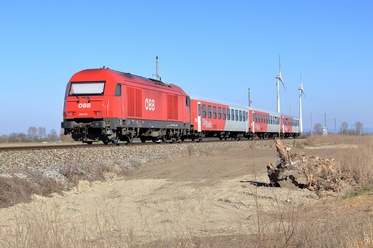 Hier ein Nachschuss auf den REX 2520, der bei bestem Licht gerade zwischen Glinzendorf und Siebenbrunn-Leopoldsdorf unterwegs ist. Geschoben wird die Garnitur von der 2016.018. Wie man an den Stromleitungsmastgen erkennt, ist der Ausbau der Strecke Wien-Marchegg bereits in vollem Gange. (16.03.2020)