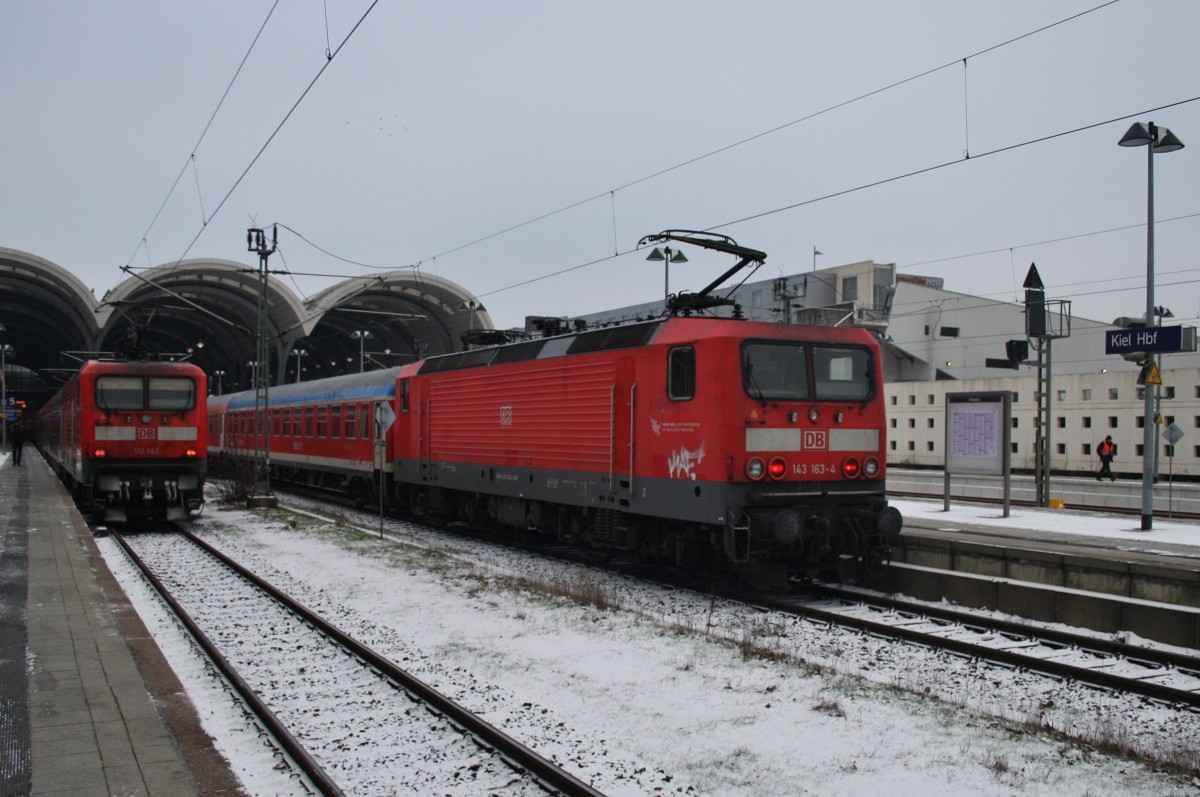 Hier links 112 143 mit einem RE70 (RE21025) von Kiel Hbf. nach Hamburg Hbf. und rechts 143 163-4 mit einer RB77 (RB21118) von Neumünster nach Kiel Hbf., diese beiden Züge begegneten sich am 19.1.2016 in Kiel Hbf.  