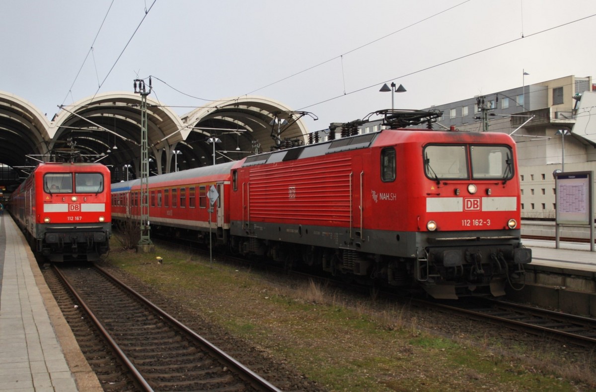 Hier links 112 167 mit einem RE70 (RE21027) von Kiel Hbf. nach Hamburg Hbf. und rechts 112 162-3 mit einer RB77 (RB21127) von Kiel Hbf. nach Neumünster, diese beiden Züge begegneten sich am 23.2.2016 in Kiel Hbf.