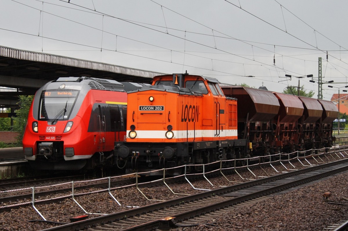 Hier links 442 329-9 als RE7 (RE18719)  Airport-Express  von Berlin Schönefeld Flughafen nach Bad Belzig und rechts 201 222-7 mit vier Schüttgutwagen, diese beiden Züge begegneten sich am 14.6.2014 in Berlin Schönefeld Flughafen.