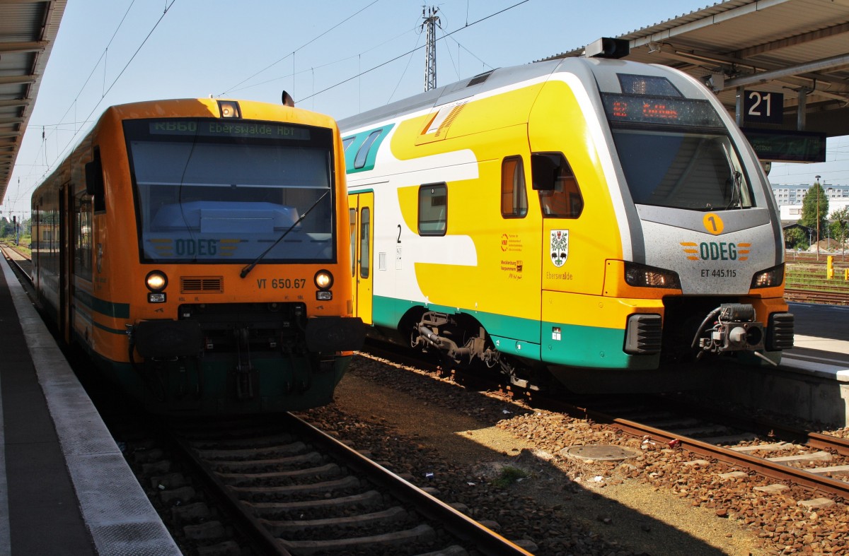 Hier links 650 067-2  Oderbruch-Hauptstadt Wriezen  als RB60 (RB79551) von Berlin Lichtenberg nach Eberswalde Hbf. und rechts 445 115-9   Eberswalde  als RE2 (RE92964) von Berlin Lichtenberg nach Cottbus, diese beiden Triebzüge standen am 19.7.2014 in Berlin Lichtenberg.