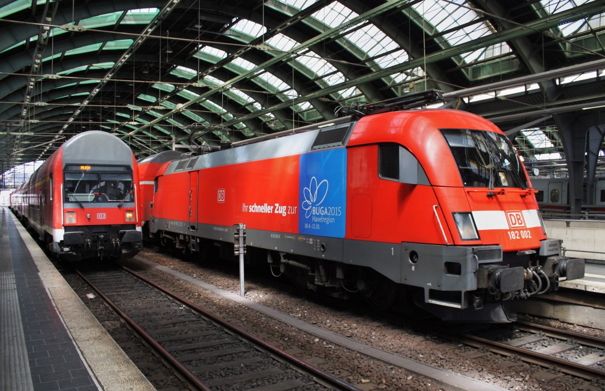 Hier links eine RB14 (RB18916)  Airport-Express  von Berlin Ostbahnhof nach Nauen (Zuglok war 143 306-9) und rechts 182 002 mit einem RE1 (RE18179) von Brandenburg Hbf. nach Frankfurt(Oder), diese beiden Züge standen am 30.6.2015 in Berlin Ostbahnhof. 