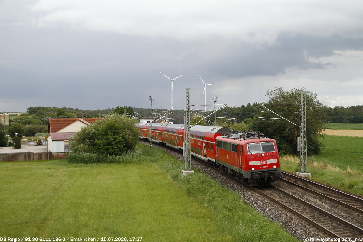 Hier zu sehen ist die 111 158, wie sie ihren Verstärkerzug, welcher aus 5 Dostos besteht durch Hagenbüchach weiter Richtung Würzburg zieht.
