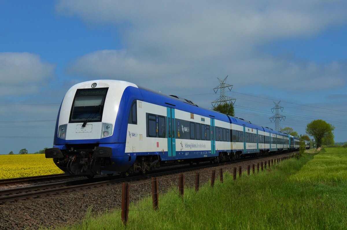 Hier zu sehen ist eine Married Pair Garnitur die am 30.05.21 als RE6 (RE 11012) auf dem weg von Hamburg-Altona nach Westerland war. Dabei wurde wenige Meter vorher der BÜ Hove in Wilster überquert.