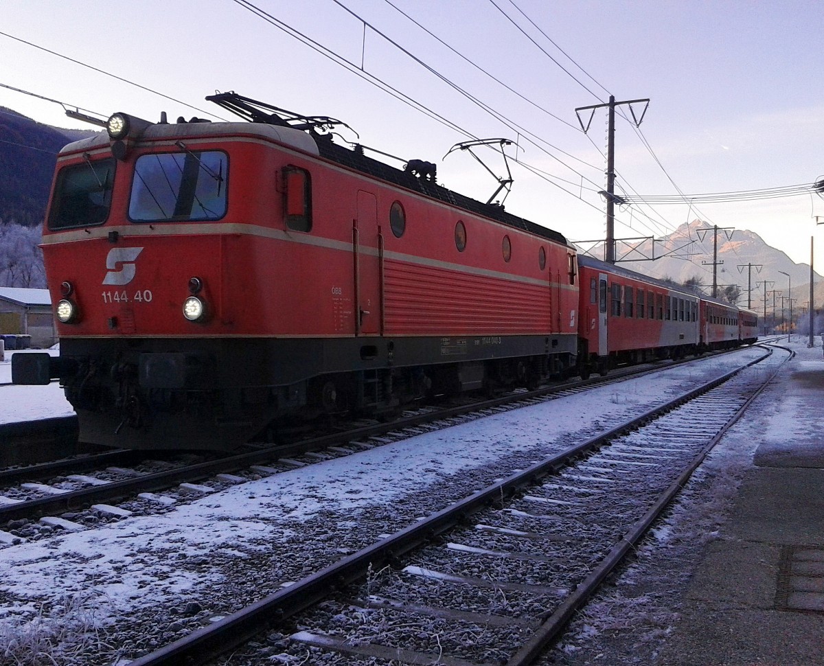 Hier zu sehen ist die noch im blutorangenen Design mit elfenbeinfärbigen Zierlinien lackierte 1144 040-3 mit R 4863 (Lienz - Spittal-Millstättersee) am 4.12.2015 in Dellach im Drautal. 