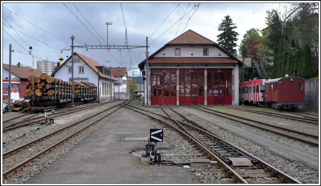 Hinter dem Depotgebäude von Tramelan steht einer der Triebwagen der Frauenfeld-Wil Bahn, die dort überflüssig wurden. Sie werden hier in der CJ Werkstätte den Bedürfnissen der Chemin de fer du Jura angepasst. An mehreren CJ Stationen sah ich geschemelte Langholzwagen. (12.05.2014)