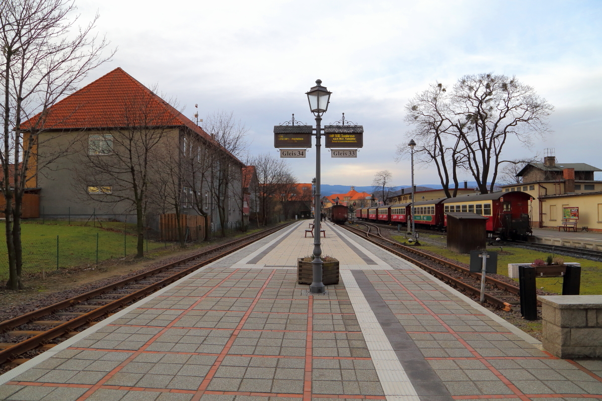 HSB-Bahnhof Wernigerode am Vormittag des 07.02.2016. Wie am Zugzielanzeiger der Bahnsteiglaterne angezeigt wird, steht auf Gleis 33 ein Sonderzug der IG HSB zur Fahrt nach Eisfelder Talmühle bereit, welcher in Kürze von Dampflok 99 6001 übernommen wird. Der rechts auf Gleis 31 stehende Planzug wird wenige Minuten vorher unter Traktion von 99 222 zum Brocken aufbrechen.