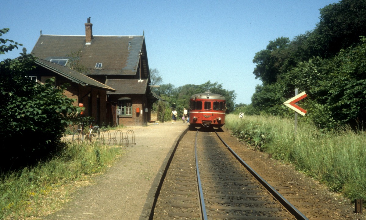 HTJ (Høng-Tølløse-Jernbane): Haltepunkt Løve am 23. Juni 1983. - Das Städtchen Løve liegt an der Bahnstrecke Slagelse - Høng 10,1 km nördlich von Slagelse. Als DSB 1898 die Bahn zwischen Slagelse und Værslev öffnete, bekam auch Løve einen Bahnhof, den der Architekt Heinrich Wenck entworfen hatte. - 1971 stellte DSB den Personenverkehr von Slagelse nach Værslev ein. Die HTJ übernahm gleichzeitig den Transport der Fahrgäste auf der Bahnstrecke Høng - Slagelse. - Der Haltepunkt in Løve wurde im Dezember 2011 geschlossen. 