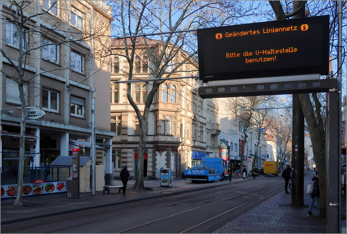 i Geändertes Liniennetz i -

Bitte die U-Haltestelle benutzen.

Durch den fehlenden Straßenbahn- und Stadtbahnverkehr wirkt jetzt die Karlsruher Kaiserstraße schon etwas verödet. Noch liegen die Gleise und auch die Fahrleitungen sind vorhanden. Seit dem 12.12.2021 fahren oberirdische keine Bahnen mehr durch die Fußgängerzone zwischen Kronenplatz und Europaplatz. Auch auf dem Abzweig vom Marktplatz in Richtung Hauptbahnhof liegen die Gleise unterirdisch.
Der Schienenverkehr in der Fußgängerzone war für Karlsruhe so was wie ein Alleinstellungsmerkmal und so scheint hier erst einmal was zu fehlen. 
Die ursprüngliche Planung neben der Tunnelstrecke (für die S-Linien) oberirdisch die Straßenbahnlinien weiterhin durch die Innenstadt fahren zu lassen hatte durchaus seinen Charme. Im Spätverkehr wäre der gesamte Verkehr oberirdisch betrieben worden.

Ehemalige Haltestelle 'Marktplatz', 12.01.2022 (M)