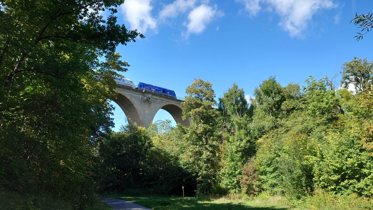 IC 2152 (Gera-Düsseldorf) auf dem 38,5m hohen Ilmviadukt in Weimar, auch Sechsbogenbrücke genannt. Seit Anfang September 2022 wird der Zug zwischen Gera und Gotha nicht mehr von einer DB 245, sondern der 246 011 der Press (interne Nummer 246 049) befördert.
Leider kann man von dem 155 m langen Viadukt wegen der Vegetation nur diesen kleinen Teil sehen, erreichbar über den Ilmtal-Rad-und Wanderweg.

Aufnahme vom 27.9.22