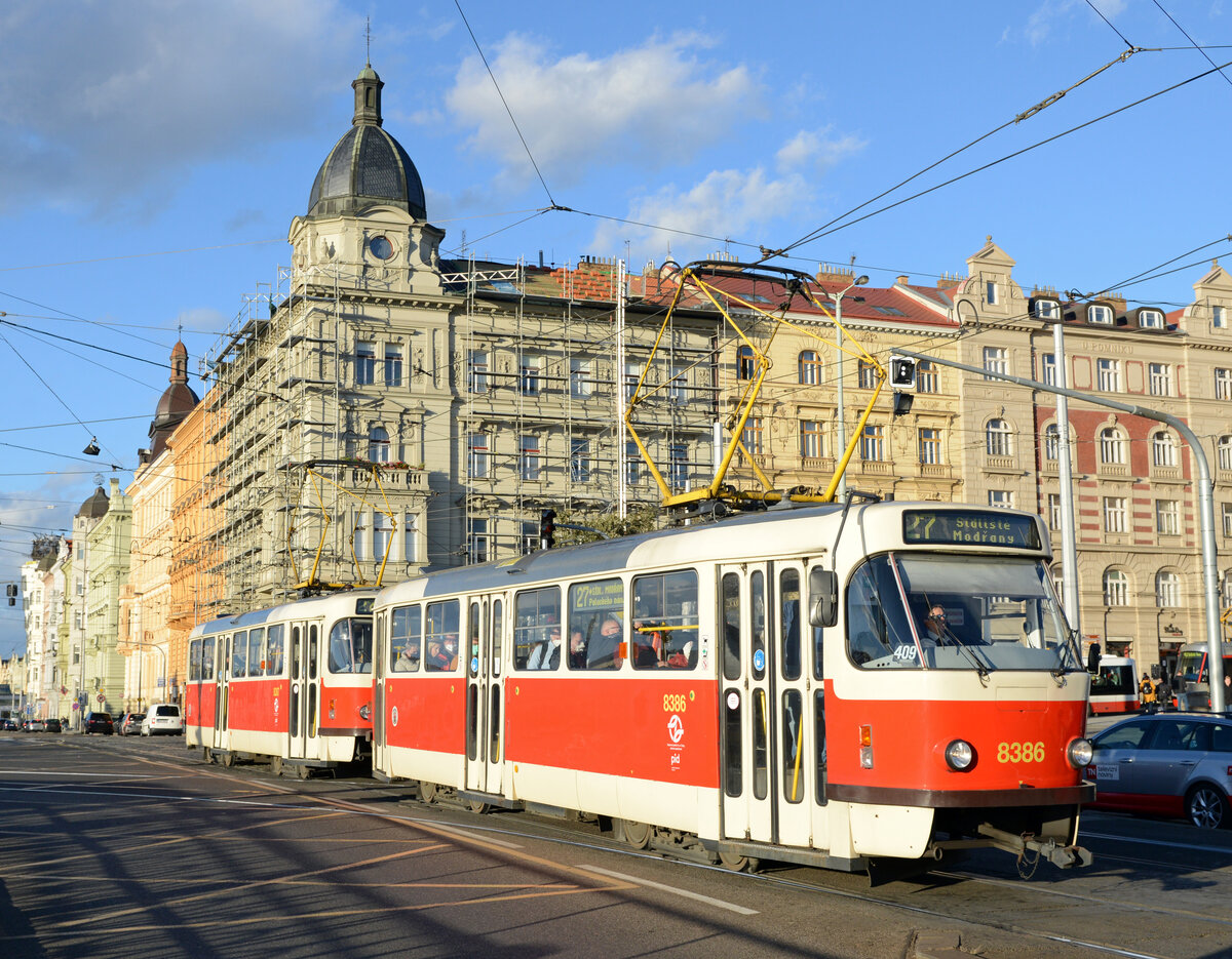 Im Abendlicht des scheidenden 21. Oktober 2021 waren die beiden T3RP Triebwägen 8386 und 8387 auf dem Palackého náměstí als Linie 27 die Moldau strom aufwärts fahrend nach Sídliště Modřan unterwegs.