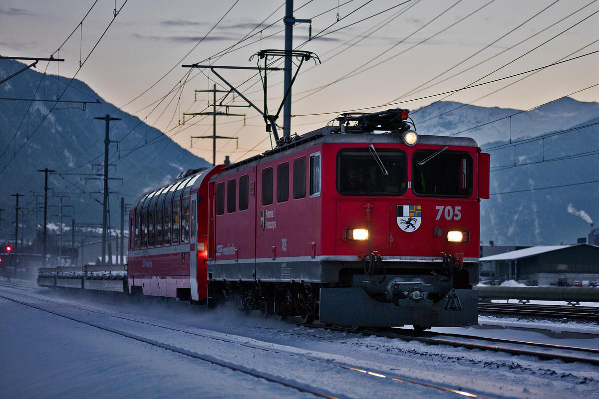 Im allerletzten Büchsenlicht braust die Ge 6/6 II 705  Pontresina  mit einem Güterzug durch das verschneite Fideris.Bild vom 9.1.2017
