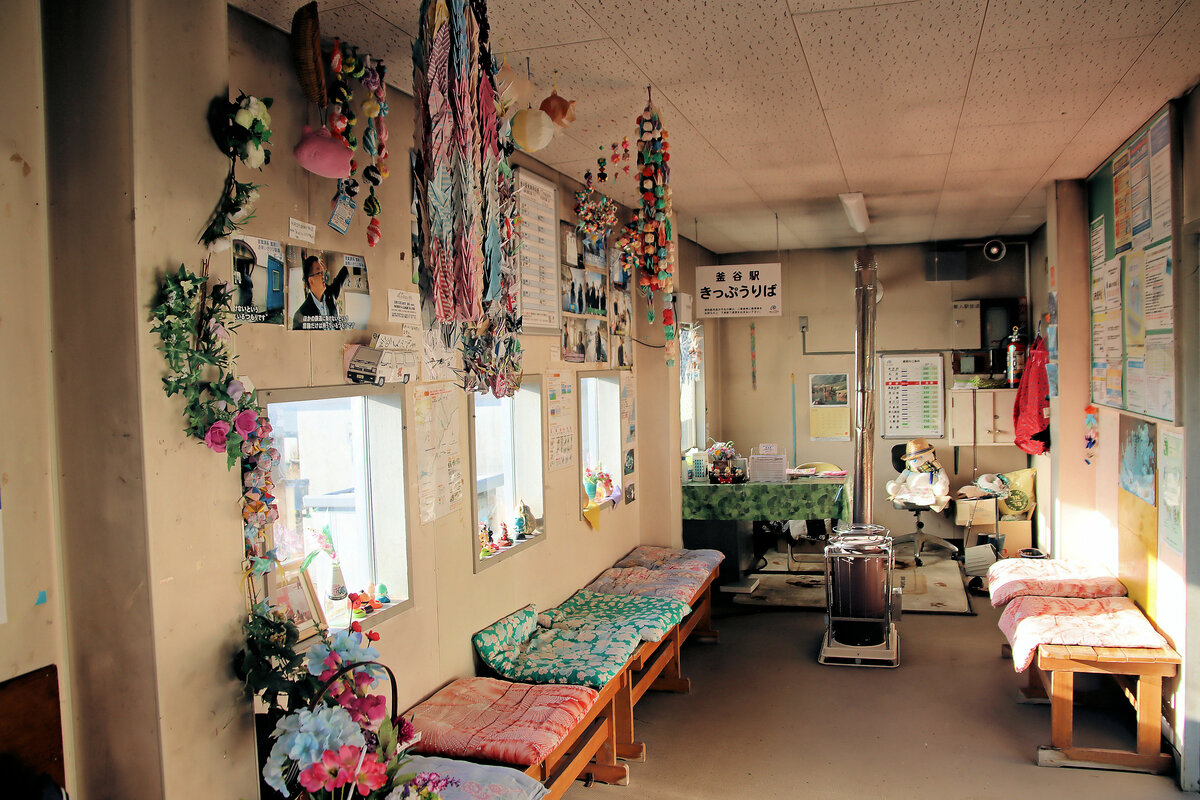 Im alten Güterwagen, der das  Stationsgebäude  von Kamaya auf der Dônan Isaribi-Bahn bildet: Vorne links ist ein Tisch mit der Anzeige  Fahrkartenverkauf . Und im Winter kann sich schön am Ofen wärmen, während man auf den Diesel-Triebwagen wartet. Als ich da war, stand die Station offen, doch weit und breit war niemand zu sehen, so konnte ich nichts Näheres erfahren. 30.Oktober 2022 