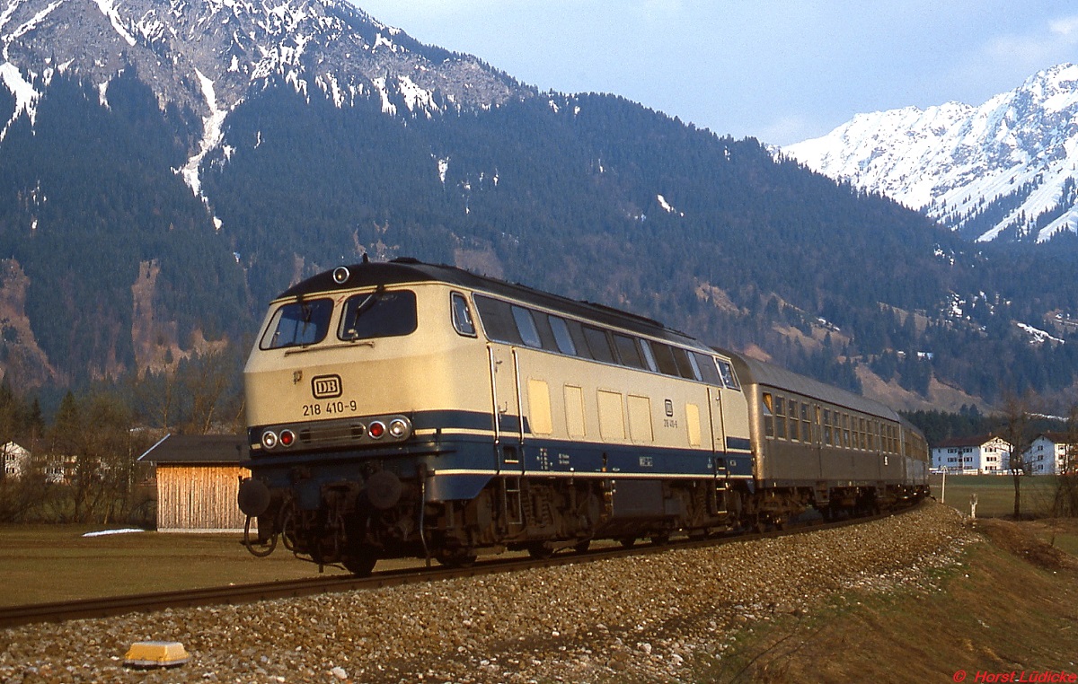 Im April 1982 ist 218 410-9 bei Oberstdorf mit einem Nahverkehrszug nach Immenstadt unterwegs