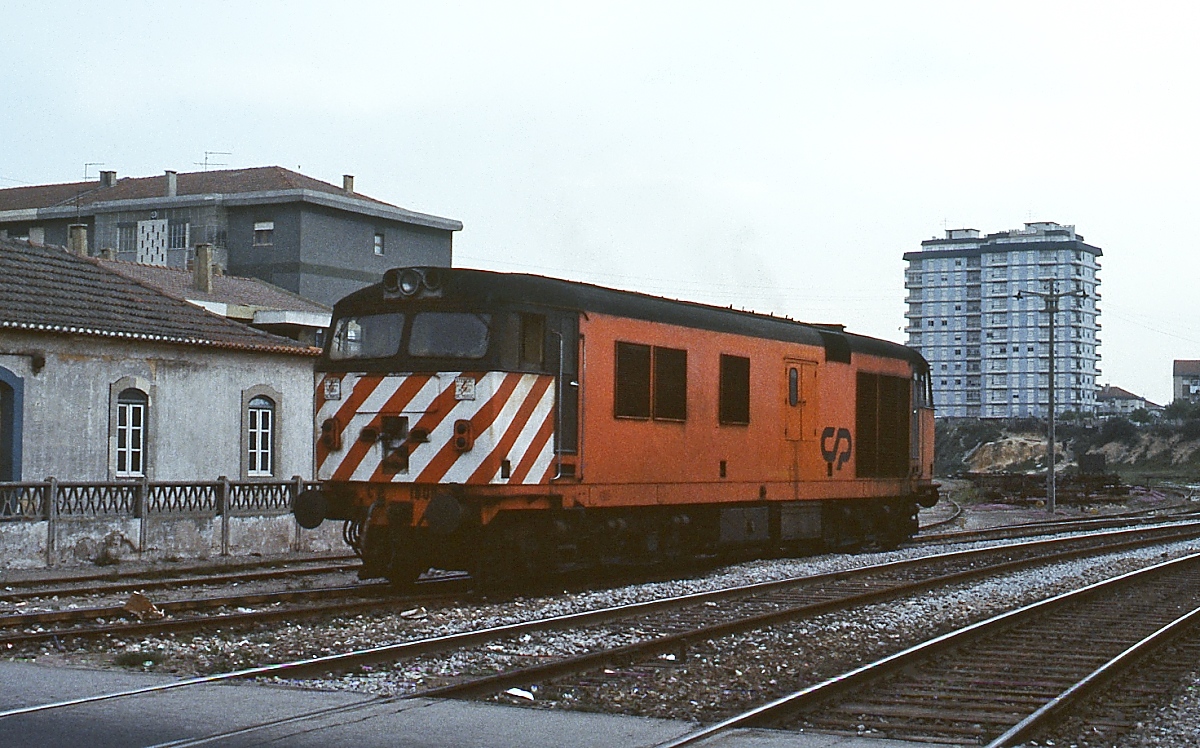 Im April 1984 überquert die CP 1808 einen Bahnübergang unweit des Bahnhofes Barreiro am südlichen Tejoufer. Sie gehört zu einer Serie von 10 Maschinen, die die englische Vulcan Foundry 1969 an die CP lieferte.