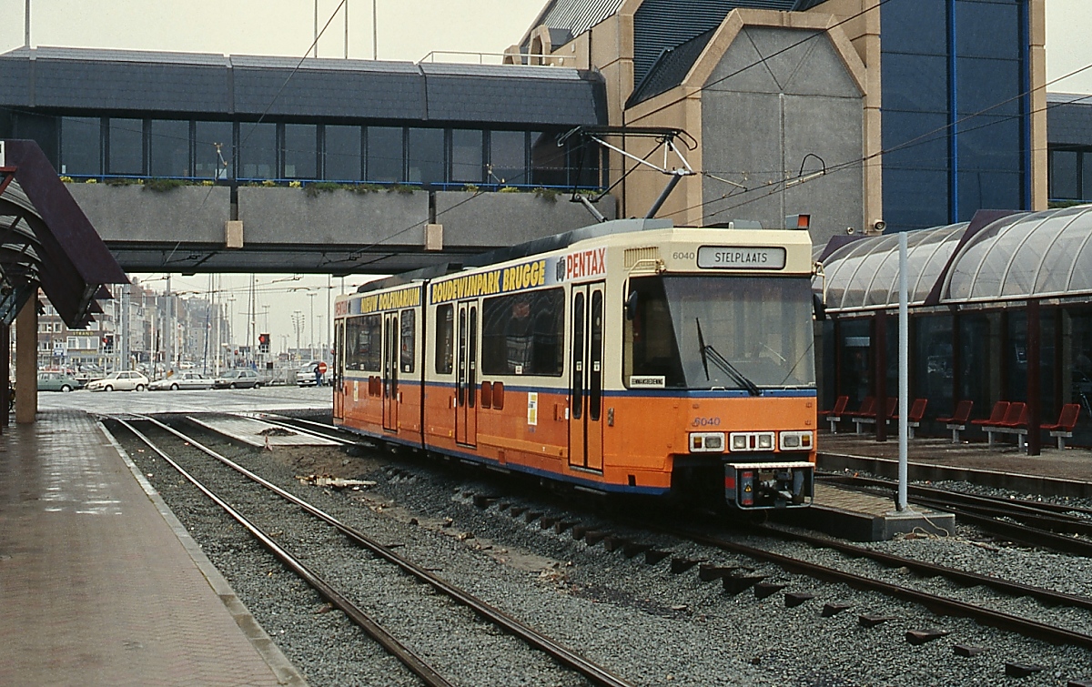 Im April 1992 präsentiert sich die Haltestelle am Bahnhof Oostende gegenüber der vorherigen Aufnahme völlig verändert: Die Bahnsteige sind modernisiert und eine Fußgängerüberführung verbindet Bahnhof und Haltestelle. Verschwunden sind auch die Dreiwagenzüge, inzwischen verkehren auf der Kusttram moderne Sechsachser, hier die Nr. 6040. Zwischen der Ankunft der Fähre aus Dover und der Abfahrt des Zuges in Richtung Heimat blieb gerade noch genug Zeit für diesen Schnappschuss.