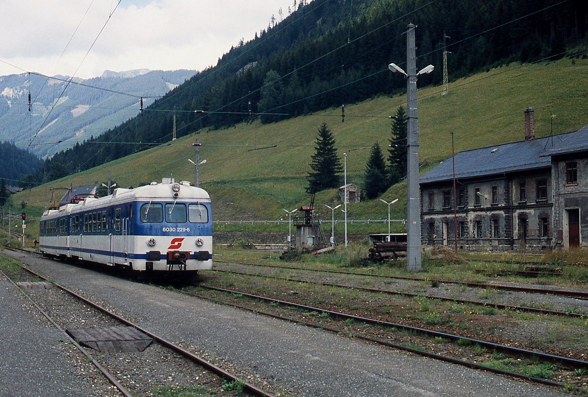 Im August 1997 fährt der 4030 229-1 mit dem führenden Steuerwagen 6030 229-6 aus Vordernberg Markt kommend im Bahnhof Vordernberg ein. Die Gleise des Bahnhofs und teilweise auch die Anlagen des ehemaligen Heizhauses sind zwar noch vorhanden, doch strahlt der Bahnhof inzwischen nur noch Leere aus. Dazu passt auch die verblichene Front des Steuerwagens.