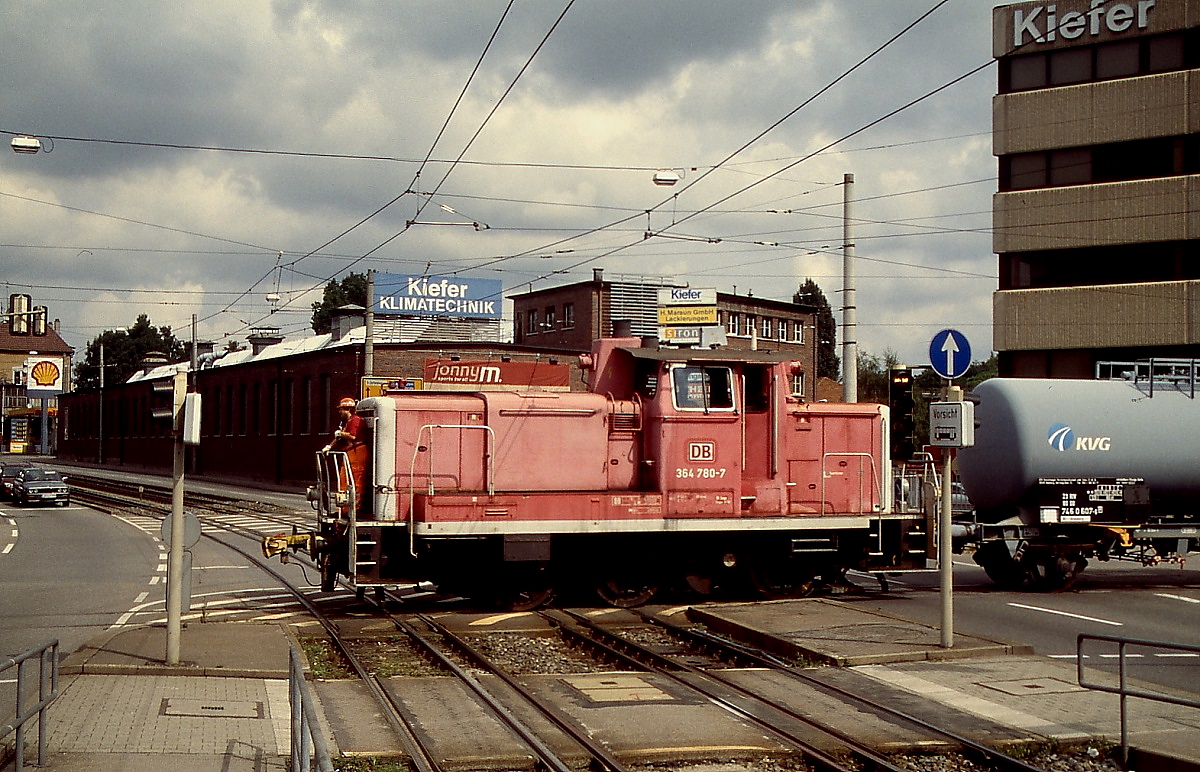 Im August 1998 kreuzt 364 780-7 mit einer Übergabe auf der Feuerbacher Industriebahn die Dreischienengleise der Stuttgarter Straßen- bzw. Stadtbahn an der Kreuzung Heilbronner Straße/Borsigstraße. Dieser Abschnitt der Feuerbacher Industiebahn wurde 2012 stillgelegt.