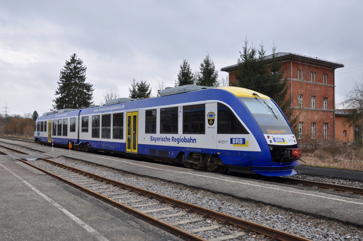 Im Bahnhof Aichach wartet ein Alstom Coradia LINT 41 der Bayerischen Regiobahn auf die Weiterfahrt nach Augsburg auf der Strecke Paartalbahn (KBS 983) am 01.03.2015. Auf einigen der Bahnen zeigt die BRB die Wappen verschiedener Ortschaften. Hier mal ein Beispiel dafür, das Wappen von Merching. 