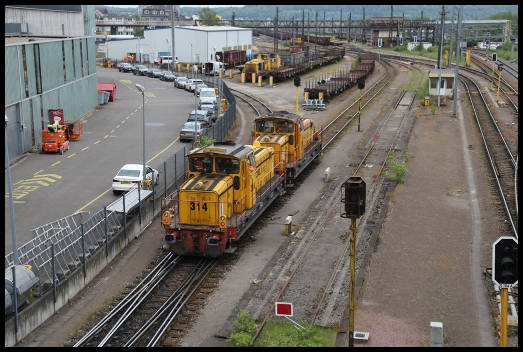 Im Bahnhof Belval Unitversite ist noch immer Werkverkehr zu beobachten. Am 23.5.2023 rangierten dort die CFL Werkloks 319 und 314 unterhalb der Fußgängerbrücke. Im Hintergrund sind weitere Werklokomotiven zu erkennen.