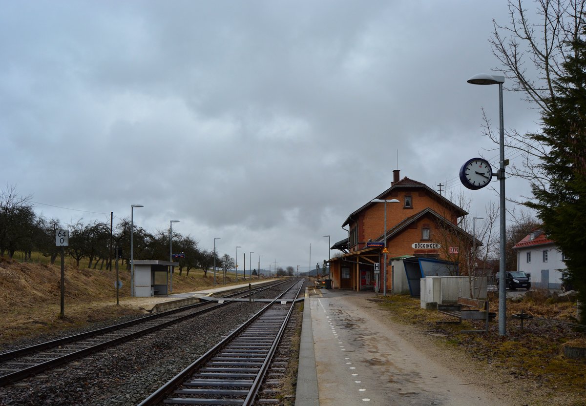 Im Bahnhof Döggingen laufen die Uhren noch langsamer. Viele Schilder sind noch mit blauen Rahmen im Stil der 70er Jahre, ebenso die Bänke und der Fahrradständer. Der Bahnhof verfügt über Formsignale und werden vom Fahrdienstleiter im Stellwerk am Empfangsgebäude mechanisch gestellt. Das Stellwerk stammt noch aus den 40er Jahren.
Seit Mai ist die Höllentalbahn wegen Bauarbeiten gesperrt und wird an vielen Stellen umgebaut. Ebenso wie Löffingen wird auch Döggingen nun umgebaut. Das Stellwerk und die Formsignale werden durch ein elektrisches Stellwerk und Lichtsignale ersetzt, die Außenbahnsteige werden durch einen Mittelbahnsteig mit einem Übergang über Gleis 1 ersetzt. Ebenso wird die gesamte Strecke elektrifiziert und nach dem Umbau wohl nur schwer wieder zu erkennen sein. 

Döggingen 28.03.2018