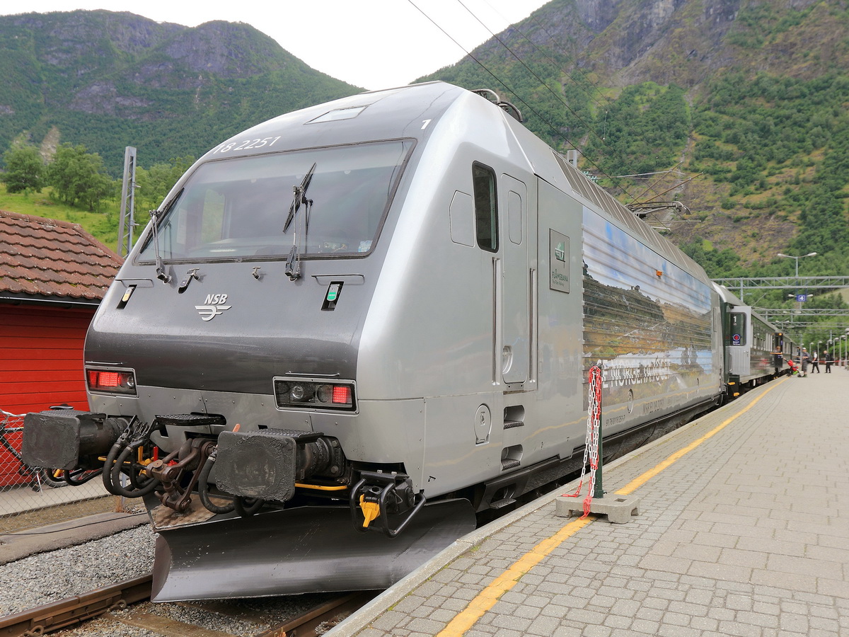 Im Bahnhof Flåm steht am 01. Juli 2016 als Schublok 18 2251 und als Zuglok 18 2247 zur Fahrt von Flåm nach Myrdal bereit. In knapp einer Stunde bringt einen  der Zug von Meeresebene in Flåm bis zum im Hochfjell gelegenen Bahnhof Myrdal in der Hardangervidda, auf 867 Metern.