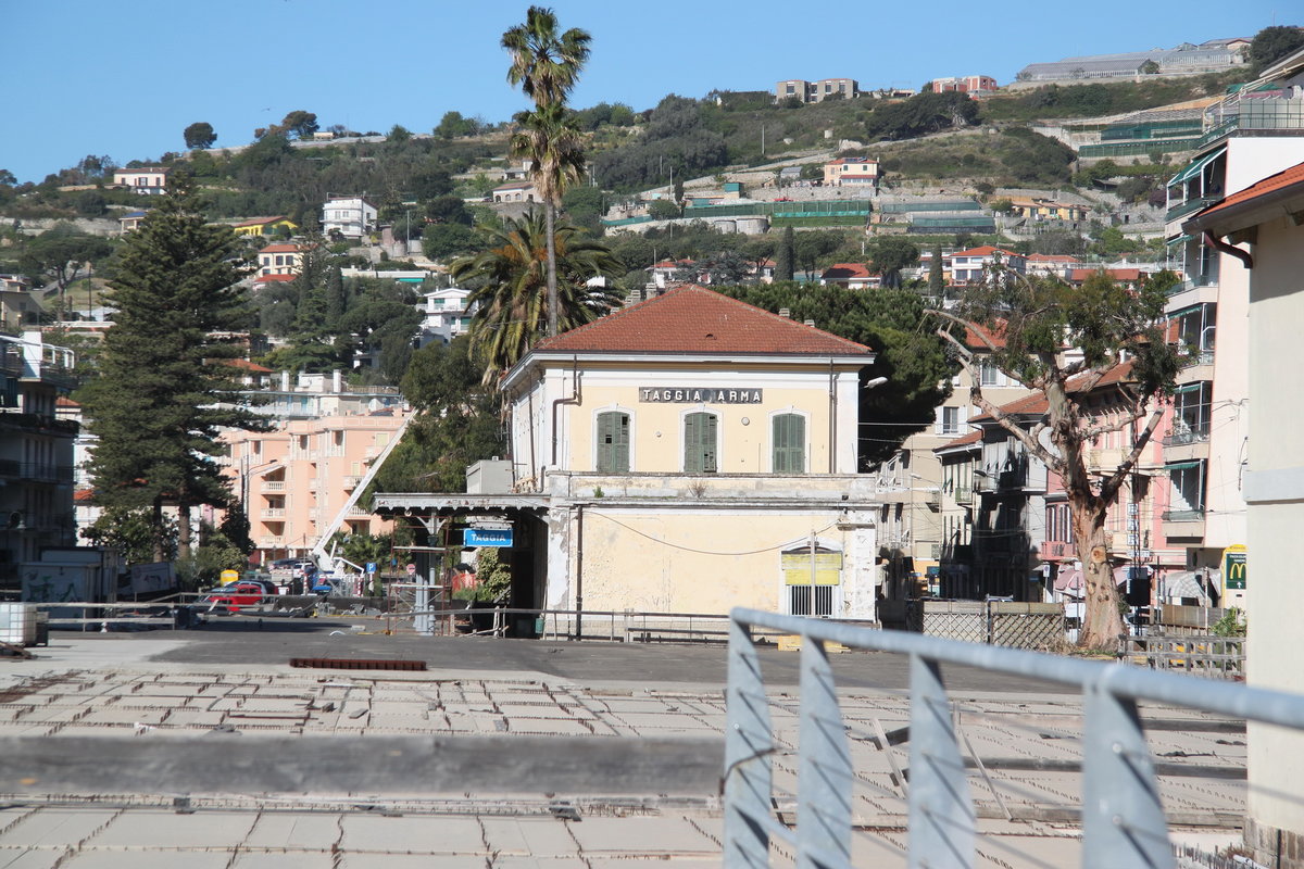 Im Bild der alte Bahnhof von Arma di Taggia.2001 fuhren hier die letzten Züge.Die Neubaustrecke verläuft heute zweigleisig weitgehend in Tunnels weiter oberhalb in den Bergen.Die Küstenstrecke wurde an diesen Abschnitten aufgegeben und als Velo und Wanderweg ausgebaut.Im Vordergrund der angefangende NB eines Parkhauses,z.Zt.stillgelegt.27.04.16