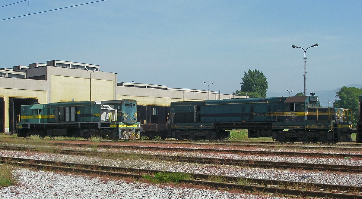 Im Depot Lisice/Skopje der mazedonischen Eisenbahn warten eine 661 und eine Lokomotive der Unterbauart 661.4 am 15.05.2009 auf ihre Ausbesserung. Im Gegensatz zu den 661.0-3 besaßen die 661.4 keine Zugheizung. Der Vorbau konnte deshalb zum besseren Streckenblick niedriger gehalten werden.