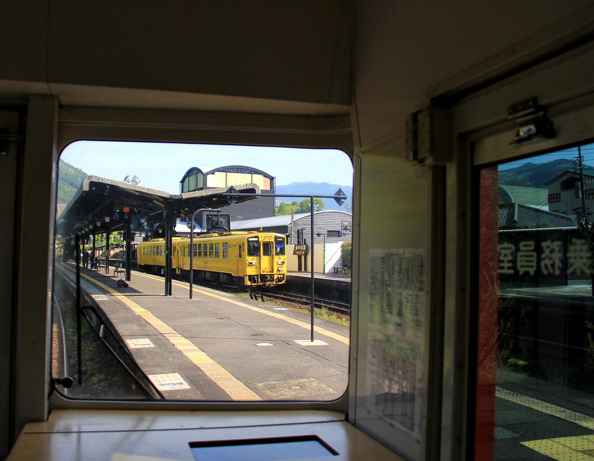 Im Erdbebengebiet von Zentral-Kyûshû: Seit dem 14.April erschüttern hier schwerste Beben von einer für uns unvorstellbaren Stärke von M.6 bis 7,3 (auf der Richterskala) das Land. Vor allem ältere Häuser und Betongebäude aus den 60er Jahren brechen in sich zusammen; Stehen ist manchmal kaum noch möglich. Dank guter Verstrebungen bei der Holzbauweise bleiben Schäden jedoch meistens auf Dach und Mobiliar beschränkt. Bild: Im Bahnhof Yufuin sind im Turm alle Scheiben geborsten; Holzlatten dienen nun dem Schutz vor Witterung. Nach mehrtägigem Unterbruch stehen die beiden Triebwagen KIHA 125-25 und 125-15 zur Abfahrt bereit. 2.Mai 2016. KYÛDAI-HAUPTLINIE 