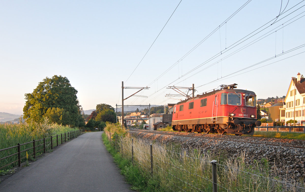 Im ersten Sonnenlicht des Tages düst die Re 430 363-2 (ehemals Re 4/4 III 11363) als Lokzug bei Wädenswil vorüber. 21.06.2018