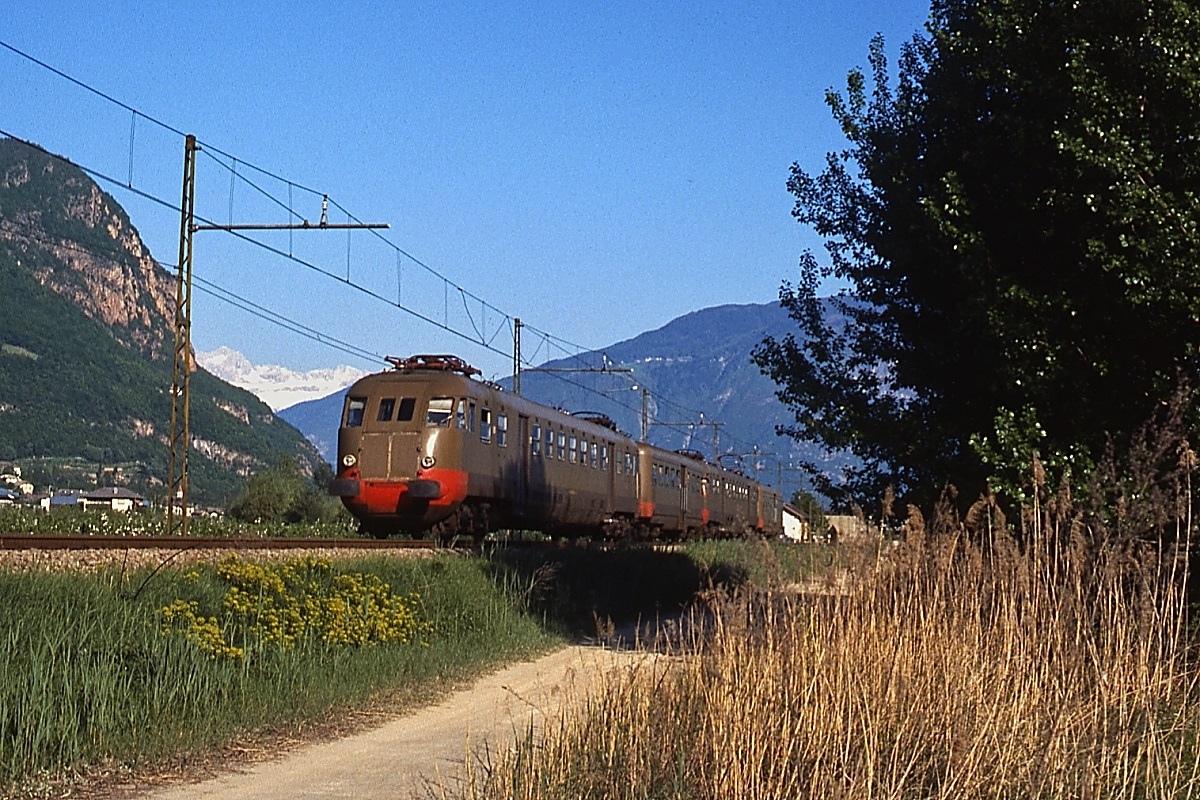 Im Etschtal sind zwei  Bozener Zigarren  der Serie ALe 840 mit Beiwagen Le 640 im April 1985 von Bozen/Bolzano nach Meran/Merano unterwegs
