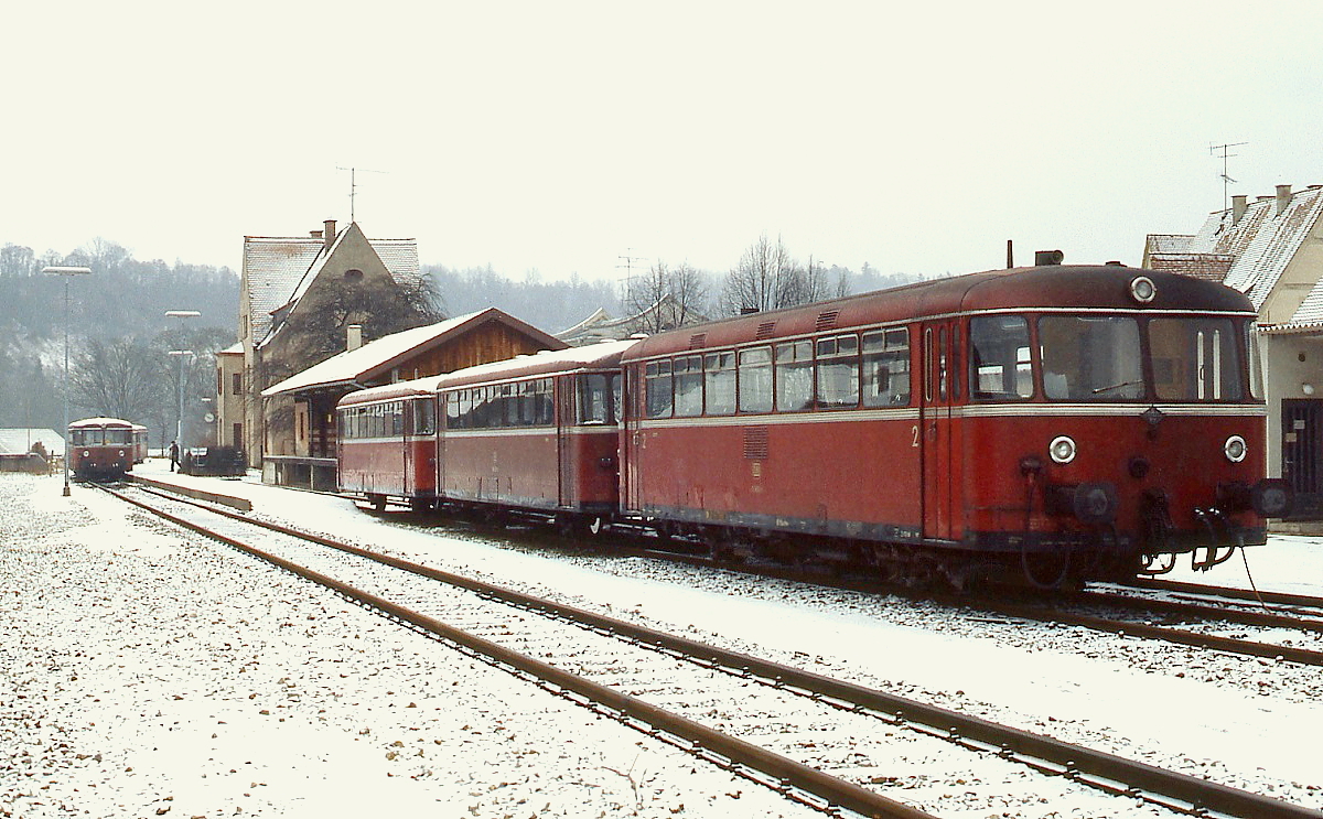 Im Februar 1986 ist eine Schienenbusgarnitur im Bahnhof Wasserburg Stadt abgestellt. Der 798 im Hintergrund wird in Kürze nach Wasserburg Bahnhof fahren. Heute befindet sich hier ein Parkplatz, das Bahnhofsgebäude existiert noch, doch anstatt der Schienenbusse fährt von dort die  Gummieisenbahn  ab. 