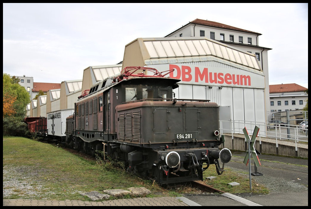 Im Freigelände des DB Museum in Nürnberg stand am 29.10.2023 die E 94281 vor einigen historischen Güterwagen.