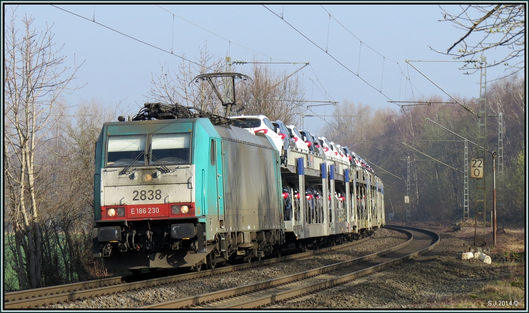 Im Frühdunst bei Rimburg legt sich die belgische 2838 (E-186) mit schwerer Last am Haken in den Gleisbogen auf der Kbs 485. Bildlich festgehalten am 12.März 2014.