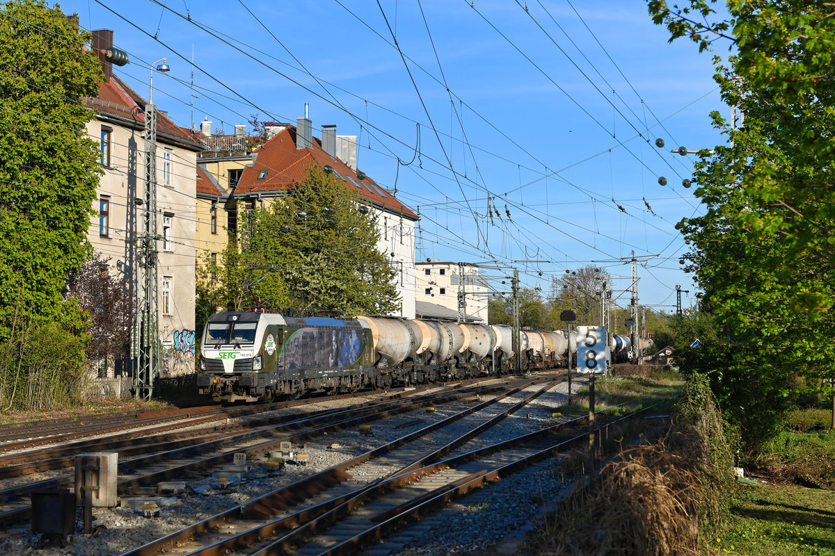 Im Frühjahr 2020 war mein Aktionsradius aufgrund der Ausgangssperren auf wenige Kilometer beschränkt. Eine der wenigen verbleibenden Möglichkeiten, um Eisenbahnbilder anzufertigen, war somit der Bahnhof München Süd. Dort fuhr mir am 15. April 2020 zum dritten Mal in Folge der Beethoven Vectron der SETG mit dem DGS 49876 nach Schwedt an der Oder vor die Linse. Daher wählte ich diese Motivvariation, um nicht drei gleichartige Bilder von der schön gestalteten Lok zu haben.  