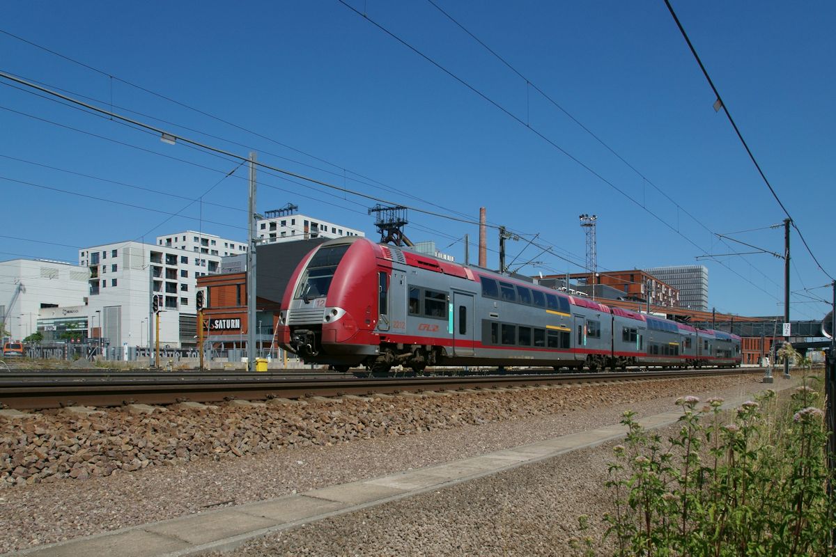 Im Gebiet Belval in Esch entsteht eine neue Stadt in der Tradition und Moderne miteinander verbunden werden. Dabei sind die beiden Hochöfen prägend für das Stadtbild. Am 8.7.2018 war CFL 2212 als RB 6765 auf dem Weg von Luxembourg Ville nach Rodange und hat gerade den Bahnhof Esch-Belval verlassen.