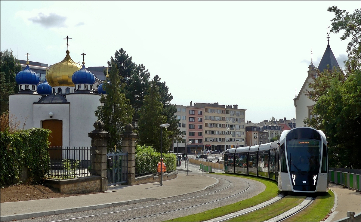 Im Gegenlicht - Ein CAF Urbos von LUXTRAM S.A. hat die vorlufige Endhaltestelle Streplaz/Etoile verlassen und fhrt nun durch die Rue Jean-Pierre Probst in Luxembourg-Ville Haute, vorbei an der russisch-orthodoxen Kirche der Heiligen Apostel Petrus und Paulus. 28.08.2018 (Jeanny)