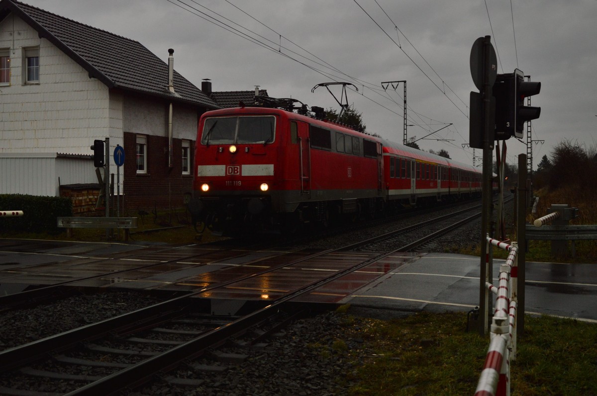 Im häftige Regen kommt die 111 119 mit N-Wagen als RE4 Verstärkerzug nach Aachen hier am Bü Dahler Weg zu sehen am heutigen Freitag den 20.2.2015