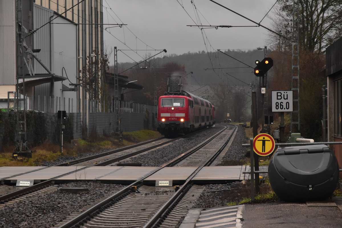 Im heftigen Regen kommt die 111 067-5 mit dem RE8 Ersatzzug samt am Zugschluß der GfF 111 200-2 durch Rosenberg Baden gefahren auf ihrem Weg nach Stuttgart. Ihr nächster Halt ist Osterburken. 8.1.2023